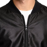 Close-up of black 1950s greaser jacket showing zipper closure, collar and leather-look fabric