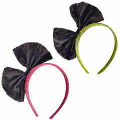 Pair of 80s-style lace headbands in pink and green, each featuring a black bow, displayed on a white background