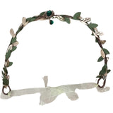 Top view of an Elven Leaf Crown with a brown base, green and gold woven leaves, front green gem in a gold casing with swirly details, and loops at the back with attached ribbons for securing