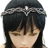 Front view of an Elven medieval fantasy crown with intricate metal textures, a silver finish, and a central gem, worn on a mannequin with a black wig, against a white background