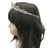 Side view of the Royal Tiara in silver, adorned with silver rhinestone crystals, showing metal combs on the side for secure placement, worn on a mannequin with a black wig, against a white background