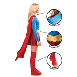 A woman modeling a Supergirl-style costume on a white background, shown in side profile with three circular callouts highlighting detachable cape, detachable belt, and felt boot tops.