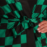 Close-up of anime-inspired kimono costume showing green and black check pattern and sash belt