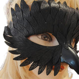 Black feathered mask on a mannequin head with blonde hair
