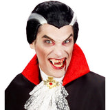 Person dressed as a vampire with a black wig, red cape, and fangs on a white background