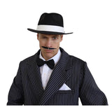 Man wearing a black pinstripe suit, bow tie, and fedora hat on a white background