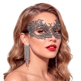 Woman wearing a silver lace mask with a white background