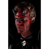 Person with red face paint and horns wearing a black shirt with a medallion