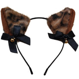 Leopard ears with fur, black bows, and gold bells on a white background