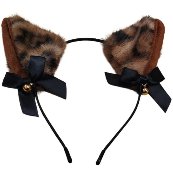 Leopard ears with fur, black bows, and gold bells on a white background