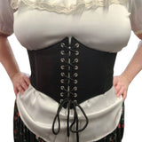 Black corset style belt worn over a white top and floral skirt on a plain background