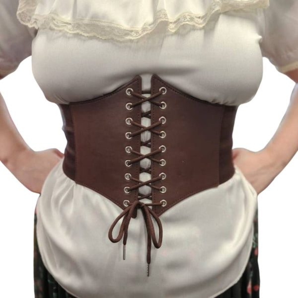 Brown corset style belt worn over a white blouse with lace details on a plain background
