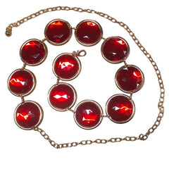 belt with red gemstones and gold chain on a white background