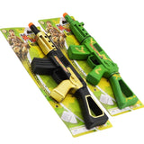 Two toy guns, one black and gold, one green, on a colorful packaging background.