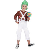 Child in a costume with a brown shirt, white overalls, green wig, and holding a lollipop on a white background