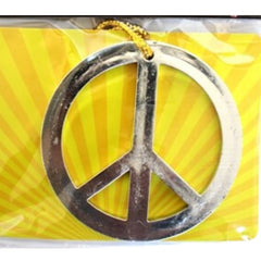 Large silver peace symbol necklace on gold cord – 1960s hippie flower power costume accessory.