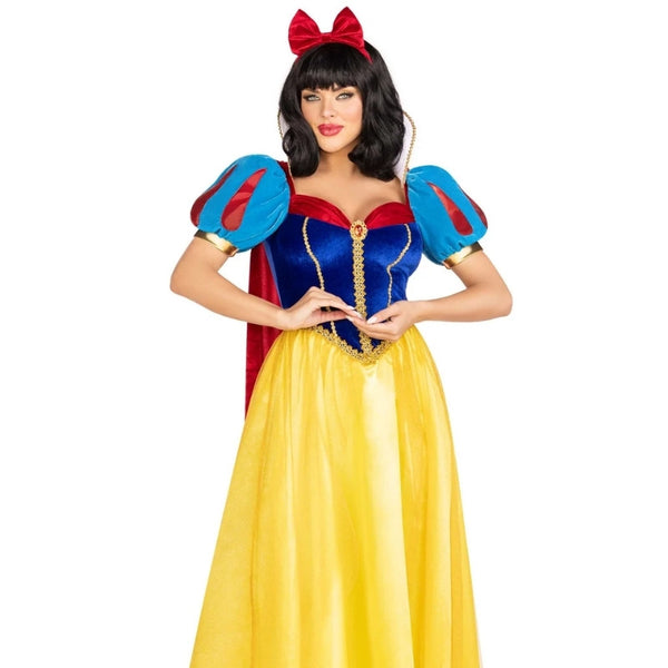 A woman modeling a Snow White costume against a plain white background. The costume features a bright yellow skirt, a blue bodice with red trim, puffed blue sleeves with red panels and gold trim, a red cape, and a red bow headband.