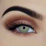 Close-up of vivid green contact lens – reusable cosmetic accessory.