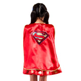 A child shown from the back wearing a red satin cape with gold trim and a large Superman logo on the back, photographed against a plain white background.